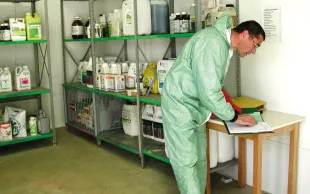 Un homme manipule des produits phytosanitaires.