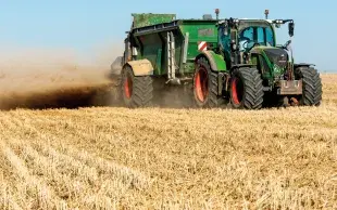 Epandage d'engrais organique dans un champ de céréale à paille non déchaumé