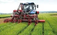 Un engin de travaux agricoles utilisé pour le relay-cropping sème une deuxième culture entre des rangs d'orge